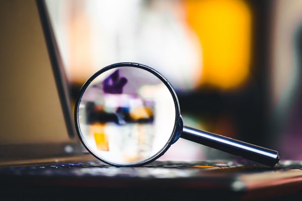 magnifying glass on laptop background check truthfinder